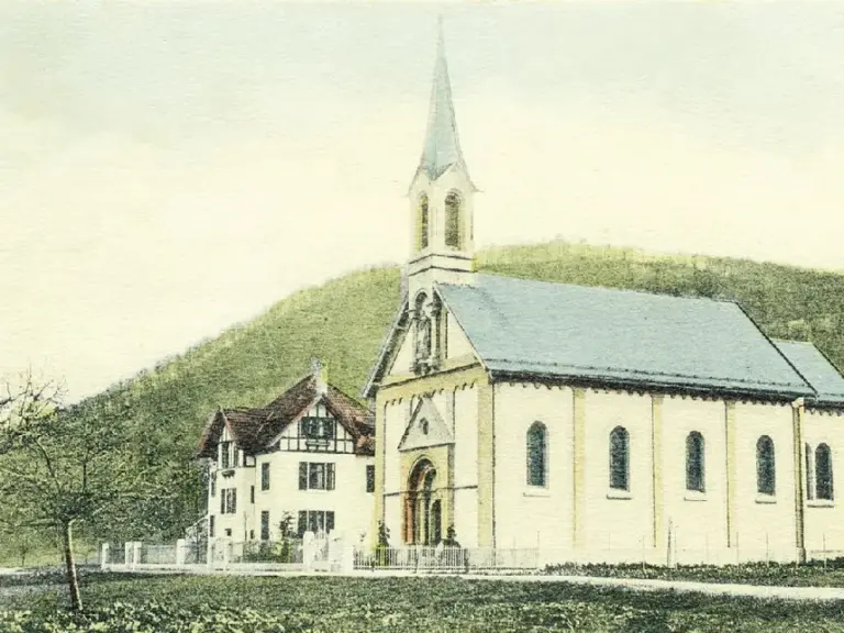 Die 1902 erbaute Kirche mit Pfarrhaus auf einer altkolorierten Aufnahme kurz nach der Fertigstellung.