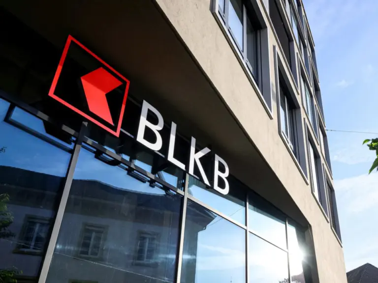 Logo und Schriftzug BLKB an der Fassade eines modernen Gebäudes vor blauem Himmel.
