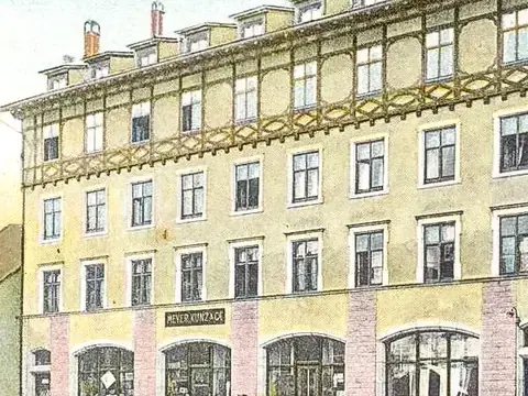 Alte Postkarte mit Fachwerkgiebel-Gebäude und Ladengeschäften, Beschriftung „Gruß aus Sissach“.