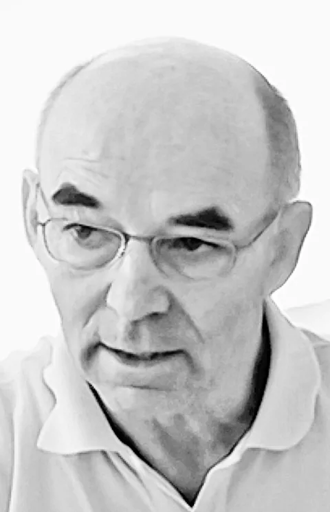 Ein älterer, kahlköpfiger Mann mit Brille und Poloshirt blickt nachdenklich zur Seite, Schwarz-Weiss-Aufnahme.